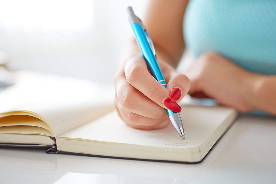 bigstock-Young-Woman-Writes-To-Black-Di-69220666
